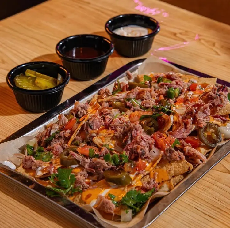 Charola de nachos con pulled pork, queso, jalapeños y cilantro