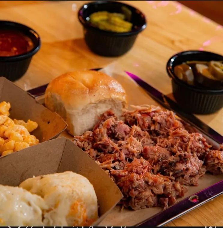 Pulled pork deshebrado sobre papel con pan, mac and cheese y jalapeños